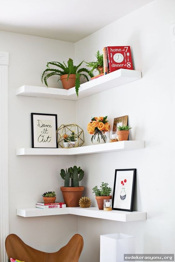 Ahşap ve metal malzemeden yapılmış modern duvar rafı modelleri, minimalist bir oturma odasında sergileniyor