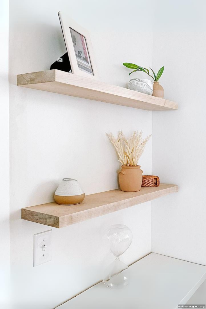 Ahşap ve metal malzemeden yapılmış modern duvar rafı modelleri, minimalist bir oturma odasında sergileniyor